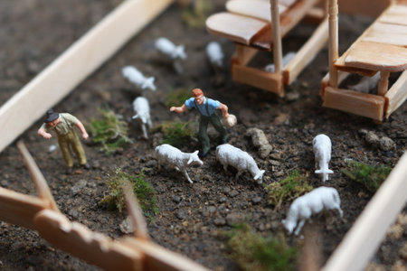 A close up of miniature figure of a goat herder feeding in a wooden cage. Shepherd concept.の写真素材