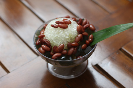 Es Kacang Merah or a cold drink made from red beans boiled with brown sugar served with coconut milk, shaved ice and covered with sweetened condensed milk chocolate and syrup. Indonesian traditional food photo concept.の写真素材