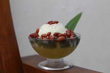 Es Kacang Merah or a cold drink made from red beans boiled with brown sugar served with coconut milk, shaved ice and covered with sweetened condensed milk chocolate and syrup. Indonesian traditional food photo concept.の写真素材