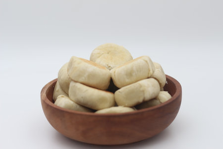 a close up of Bakpia served in a wooden bowl isolated on white background.の写真素材