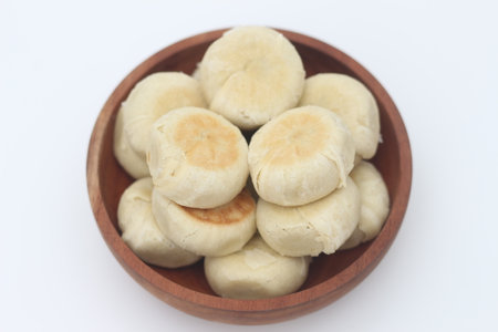 a close up of Bakpia served in a wooden bowl isolated on white background.の写真素材
