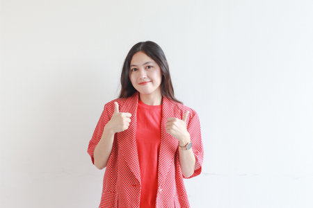 portrait of beautiful asian woman wearing red outfit with agree or OK gesture while smiling isolated white background.の写真素材