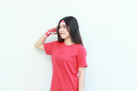 portrait of beautiful asian woman wearing red outfit celebrating Indonesia independence day with respectful gesture isolated on white background. Soft focus.の写真素材