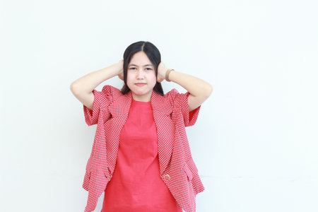 portrait of beautiful asian woman wearing red outfit gesturing to cover ears because of noise isolated white background.の写真素材