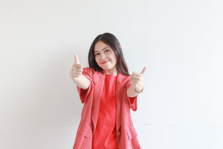 portrait of beautiful asian woman wearing red outfit with agree or OK gesture while smiling isolated white background.の写真素材