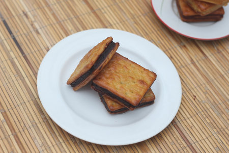 Three chocolate filled crackers on a white plate.  A tempting sweet snack.の写真素材