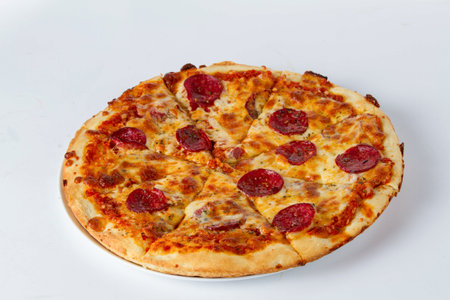 Pizza with salami and cheese isolated on a white background.の写真素材