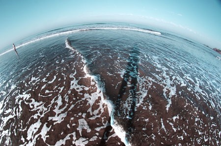Cold sea with shadow of the human on water. Fish eye