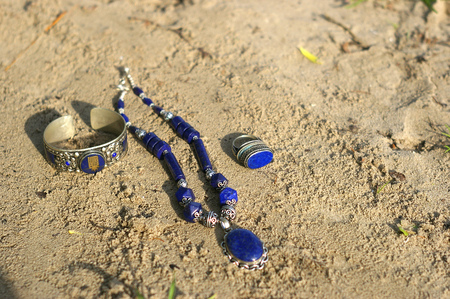Handmade. Necklace ring and bracelet on the sand on unny dayの写真素材