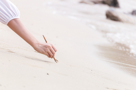 The women writing heart on sand on the beachの写真素材