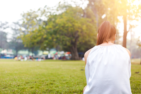 the women is on the grass and beautiful. she is sitting on the grassの写真素材