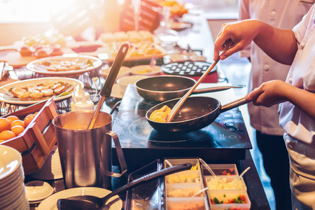 the chef cooking food in saucepanの写真素材