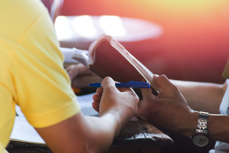 a hand hold pen and open the book on the tableの写真素材