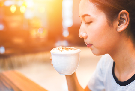 the women hold cup of coffee for drinking.の写真素材