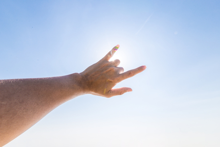 Hand of a man reaching to towards sky. Hand make symbol.の写真素材