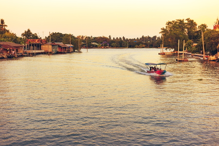 Samut Songkhram , Thailand - April 14, 2018: River cruise boats transporting people on the Mae Klong River. This is a very popular tourist attraction in the city.のeditorial素材