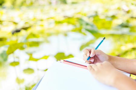 Student practice drawing by pencil in the park.The crayon is on the white paper.の写真素材