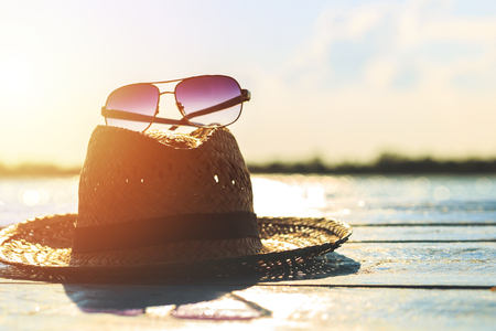 sunglasses, hat are on the ground and sunset.の写真素材