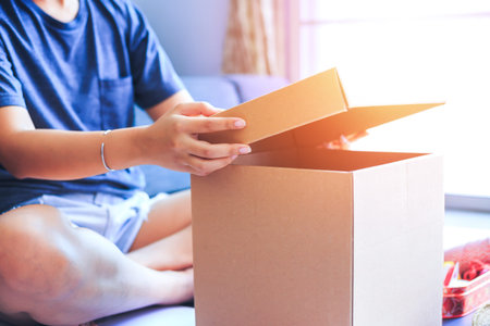 People sitting open the box in the room.