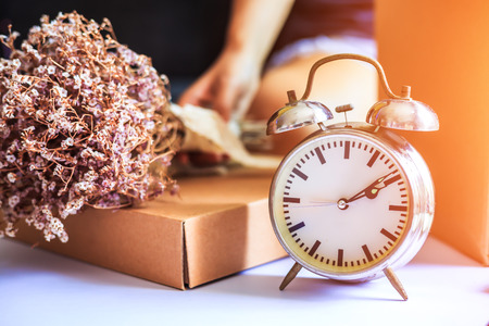 Alarm clock is on the ground near the box.の写真素材