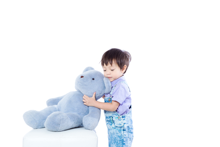 kid stand playing with the dollの写真素材
