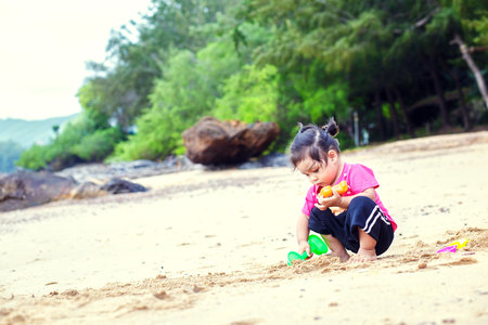 Child playing with toy on beach.の写真素材