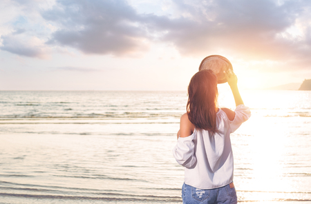 women stand on the beach and sea water between sunset and nice cloud.の写真素材