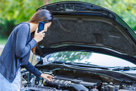 A women and broke down car on the road and she use mobile phone.の写真素材