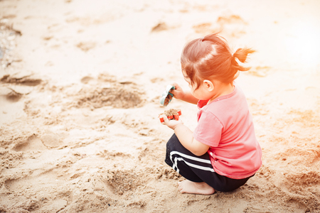 Child playing with toy on beach.の写真素材