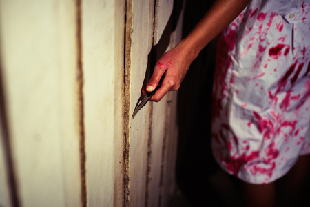 Woman holding knife with blood, halloween conceptの写真素材