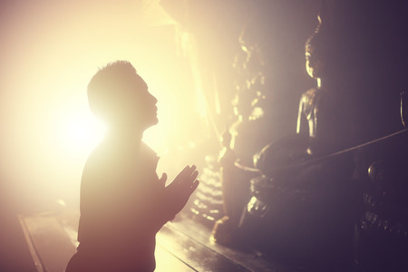 A man pay respect to the Buddha statue.の写真素材
