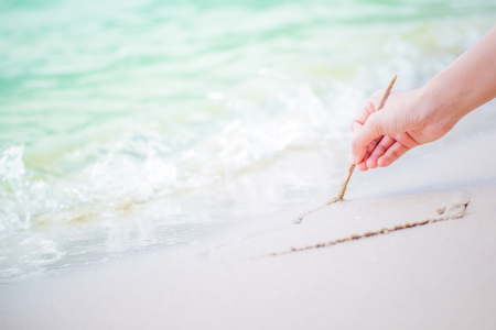 Hands writing on sand and water flow.の写真素材