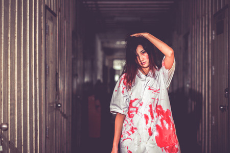Woman holding knife with blood, halloween concept.の写真素材