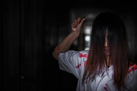 Woman holding knife with blood, halloween concept.の写真素材