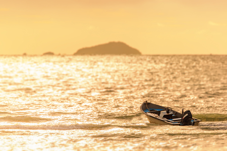 the fishing boat on the sea water and sun is background.の写真素材