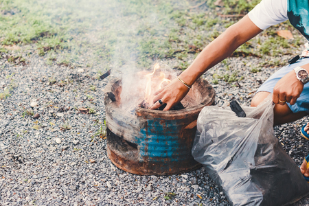 Fill charcoal briquette to hot flaming charcoal in bbq grill stove. Burning charcoal for cooking barbecue food.の写真素材