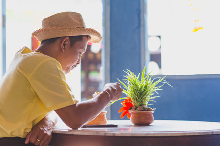 Asian man wear hat and eat ice cream coconut in the resturent.