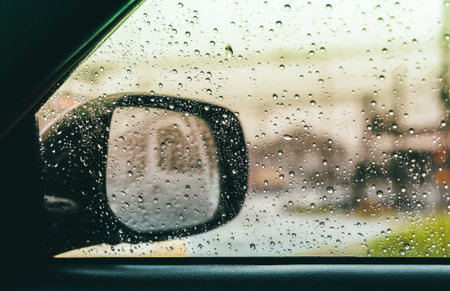 Blurred rain drop on the car glass background, water drops at the car window driver side.の写真素材