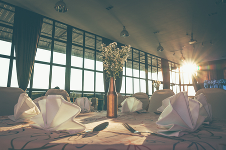 Wedding hall or other function facility set for fine dining and sun light.の写真素材