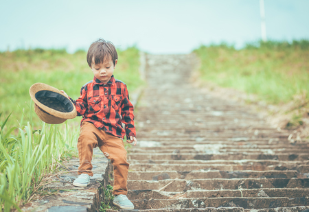 a children hold hat and walking on stair. 
A children have mucus.の写真素材