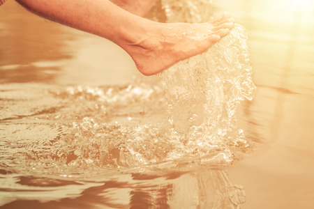 Man' foot with water splash in relaxの写真素材