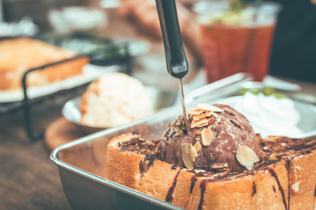 Toast bread with chocolate ice cream in plate on wooden table.の写真素材