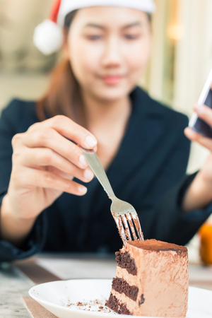 Closeup of woman eating chocolate cake in a cafe.の写真素材