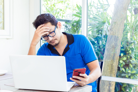 A man working on computer and having headacheの写真素材
