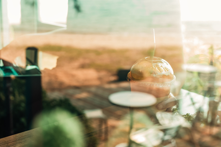 Hands hold ice tea lemon on the wood table and cactus near window grass.の写真素材