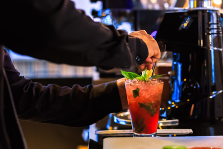 hand bartender make cocktail. Cocktail have cherry and mint leaves.の写真素材