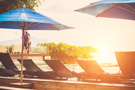 Beautiful luxury hotel swimming pool with sunset scene background.の写真素材