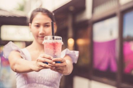 girl show glass water at the market.の写真素材