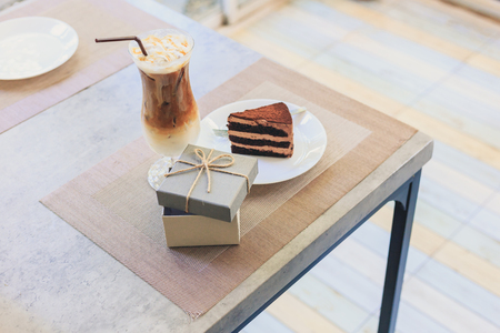 open empty gift box near Cake on dish and milk tea.they are on table.  A present on holiday.の写真素材