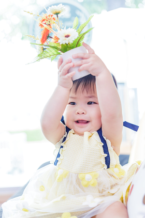 Cute baby girl hold flower at studio photo.の写真素材